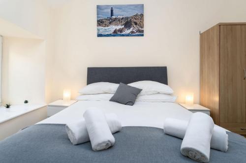 a large white bed with white pillows and a lighthouse at Property 444 - Clifden in Clifden
