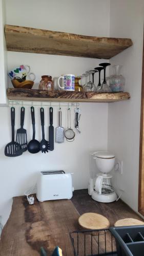 - une cuisine avec un comptoir et des ustensiles sur un mur dans l'établissement Aux Nobles Acacias, à Épagne-Épagnette