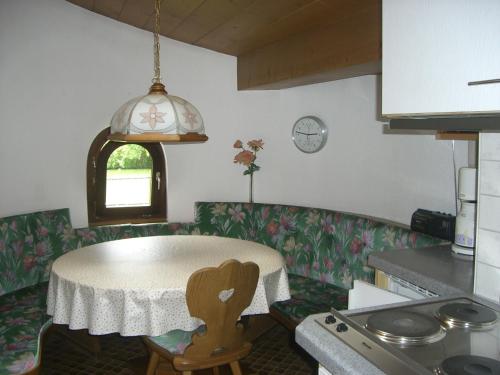 eine Küche mit einem Tisch, einem Tisch und einem Fenster in der Unterkunft Haus Ebner in Vandans