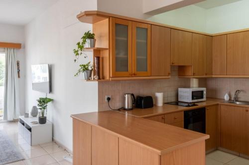 a kitchen with wooden cabinets and a counter top at Princess Residence in Ayios Dhometios