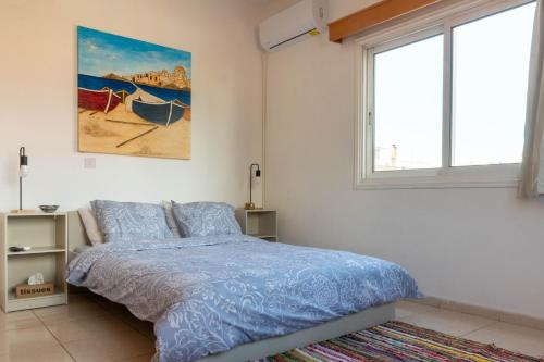 een slaapkamer met een bed en een schilderij aan de muur bij Princess Residence in Ayios Dhometios