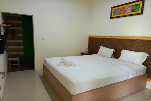 a bedroom with a large bed with white sheets at Adisa Homestay in Rampal