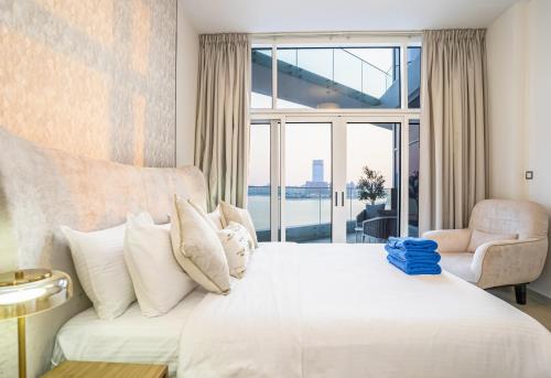 1 dormitorio con cama blanca y ventana grande en New Arabian MINA By Azizi With Private Beach & Sea View 606, en Dubái