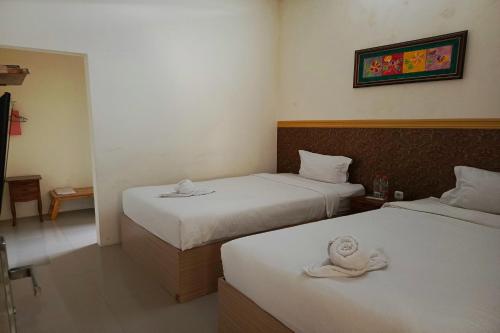 a hotel room with two beds with towels on them at Adisa Homestay in Rampal