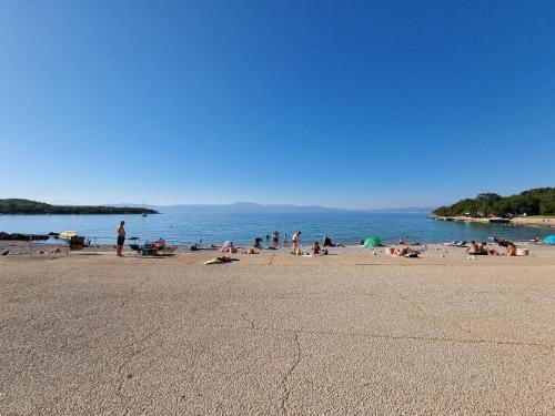 a group of people on a beach near the water at Apartment Sol Dolcevita in Njivice