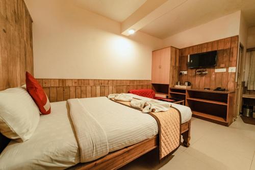 a hotel room with a bed and a tv at Vivera Highlands in Kodaikānāl