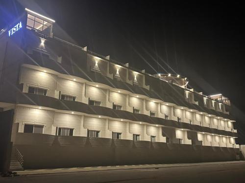 a building with lights on top of it at night at Vista Haql Hotel in Al Humaizah