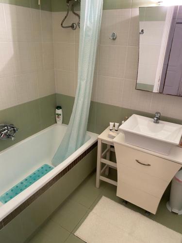 uma casa de banho com uma banheira, um lavatório e um espelho. em Thalassa em Monodhéndrion