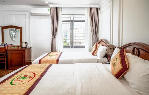 Habitación de hotel con 2 camas y ventana en Phu My Hai Hotel, en Da Nang