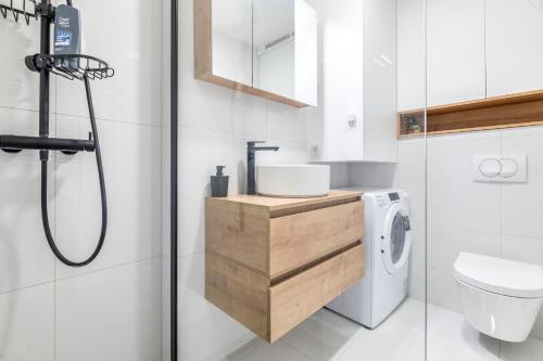 a bathroom with a sink and a washing machine at Arvia Apartment in Zagreb