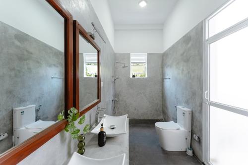 a bathroom with two toilets and a sink and a mirror at Villa Ceylanka in Talpe
