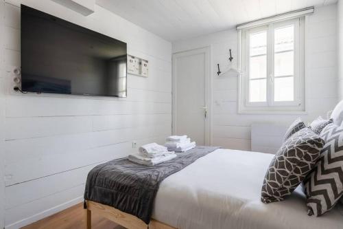 une chambre avec un lit avec une télévision au mur dans l'établissement Le Cap - Joli studio proche Gare et Nansouty, à Bordeaux
