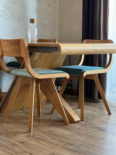 una mesa de madera y 2 sillas junto a una mesa en Deluxe Old Ungvar Apartments, en Uzhhorod