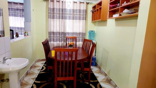 a kitchen with a table and two chairs and a sink at Lokorye Homes in Makutano