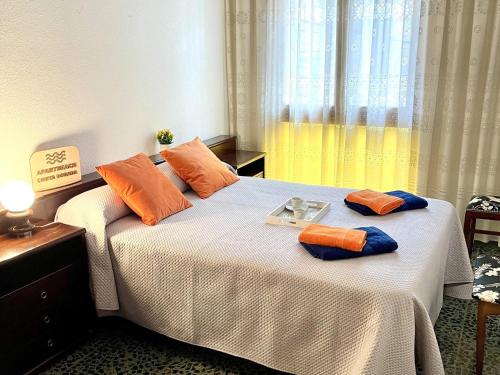 a bedroom with a bed with orange and blue pillows at APARTBEACH CASA ALFORJA con VISTAS in Alforja
