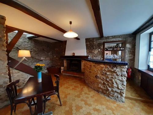 - un salon avec une table et un bar en pierre dans l'établissement Gite du Paradis, à Belval-sous-Châtillon
