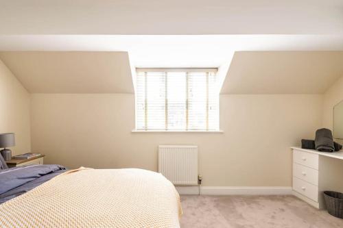 a bedroom with a bed and a window at Central Village Cottage, The Corders in Moreton in Marsh