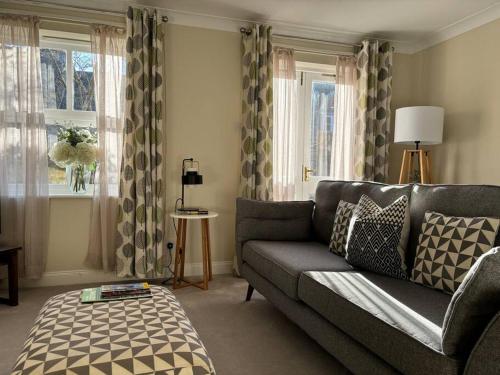 a living room with a couch and a window at Central Village Cottage, The Corders in Moreton in Marsh