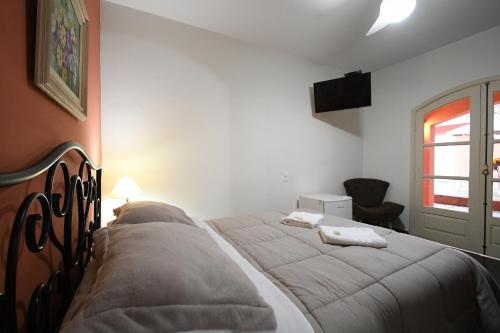 a bedroom with a bed and a window at Pousada Casa Doce Vida in Águas de Lindóia
