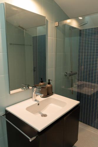 a bathroom with a sink and a shower with a mirror at North Star Flats @Santa Marinha in Vila Nova de Gaia