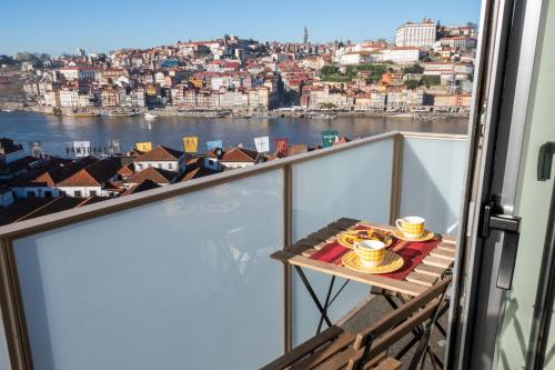 a balcony with a table with a view of the water at North Star Flats @Santa Marinha in Vila Nova de Gaia