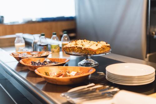 a table topped with bowls and plates and a cake at Apex2100 International Ski Academy Tignes in Tignes