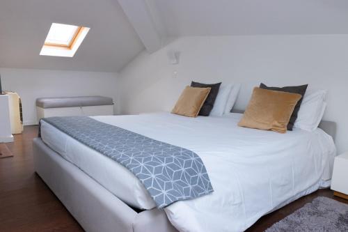 a bedroom with a large white bed with pillows at North Star Flats @Santa Marinha in Vila Nova de Gaia