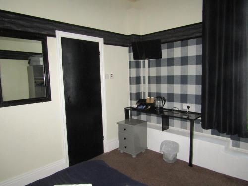 ブラックプールにあるNo12 Guesthouse South Shore Blackpoolのベッドルーム(テーブル、鏡、窓付)