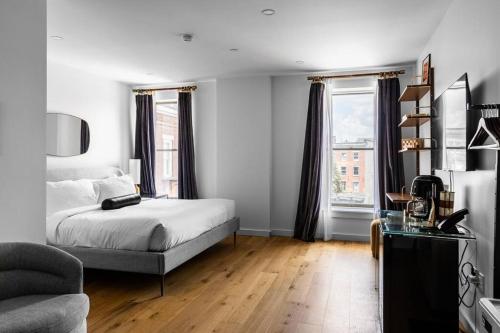 a bedroom with a bed and a desk and windows at The Phenix DTWN Historic Hotel, King Bed, Room # 307 in Bangor