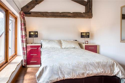 a bedroom with a large bed and two night stands at Poppy Cottage - Great Houndbeare Farm Holiday Cottages in Aylesbeare