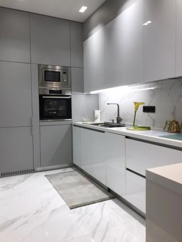 a kitchen with stainless steel appliances and white cabinets at B & K Luxury & Elegant Volos Suite in Volos