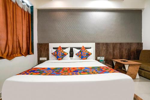 um quarto com uma cama grande e um sofá em FabHotel Galaxy I em Ahmedabad