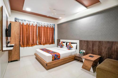 a bedroom with a bed and a couch and a table at FabHotel Galaxy I in Ahmedabad