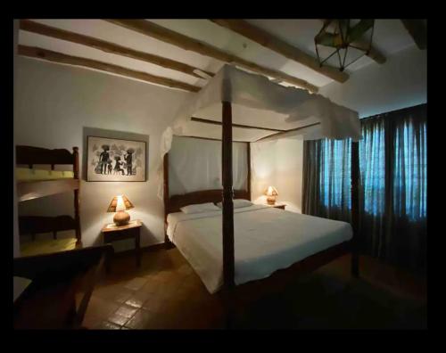een slaapkamer met een groot bed en 2 nachtkastjes bij Ornella House Resort: Spacious 5-Bed Villa in Tropical Malindi in Malindi