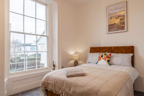 een slaapkamer met een bed en een groot raam bij Seaside Serenity: Stylish Sea View Apartments in Herne Bay in Kent