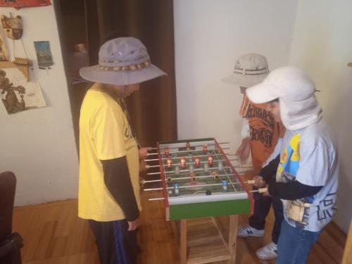 three men in hats playing with a chess game at Casa de campo hospedaje RyM in Sicuani