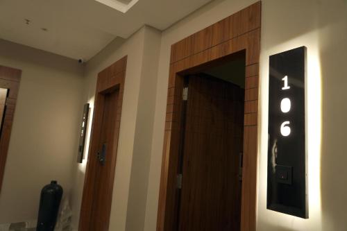 a hallway with two wooden doors and a sign on the wall at BANMALI REGENCY in Jamshedpur