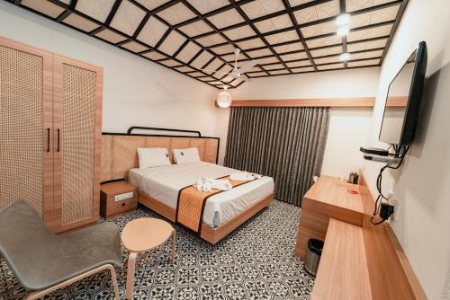 a hotel room with a bed and a tv at Vivera Highlands in Kodaikānāl