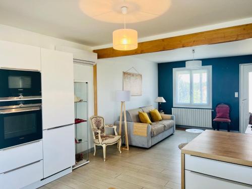 a kitchen and living room with a couch and a table at Le Cottage - Jolie Maison à Buxerolles in Buxerolles