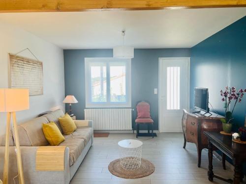 a living room with a couch and a tv at Le Cottage - Jolie Maison à Buxerolles in Poitiers