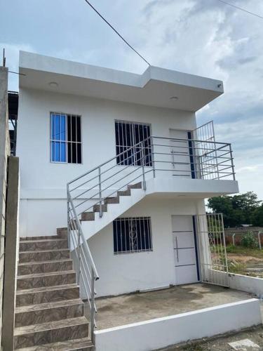 a white house with a staircase in front of it at Hostal el ebenezeer in Santa Marta