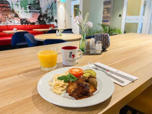 a plate of food on a table with a glass of orange juice at Good Morning Örebro in Örebro