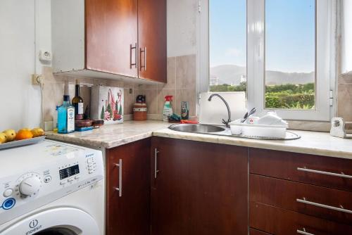 a kitchen with a sink and a washing machine at Casa São Pedro in Vila Franca do Campo