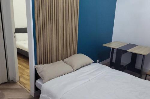 ein kleines Schlafzimmer mit einem Bett und einem Tisch in der Unterkunft Appartement accueillant aux portes de Paris in Bobigny