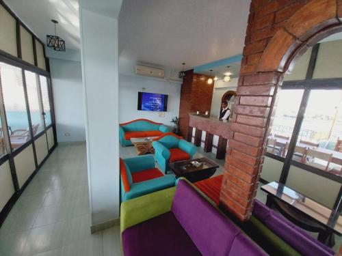 a living room with colorful furniture and a brick wall at Merryland Hotel Luxor in Luxor