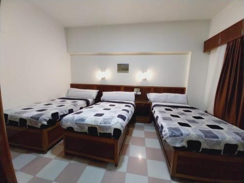 a room with three beds in a room at Merry Land Hotel & Roof Top Nile Restaurant Luxor in Luxor