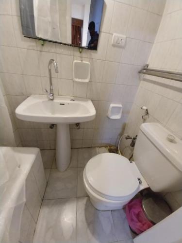 a white bathroom with a toilet and a sink at Merry Land Hotel & Roof Top Nile Restaurant Luxor in Luxor