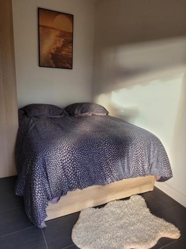 - une chambre avec un lit doté d'une couette noire et d'un tapis dans l'établissement Le Diarama, à Saint-Laurent-du-Var