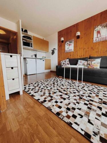 - un salon avec un canapé et un sol en damier dans l'établissement Appartement Puy Saint Vincent 1800, à Puy-Saint-Vincent