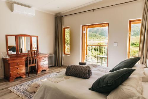 a bedroom with a bed and a dresser and a mirror at Ontevreden Farm in Montagu